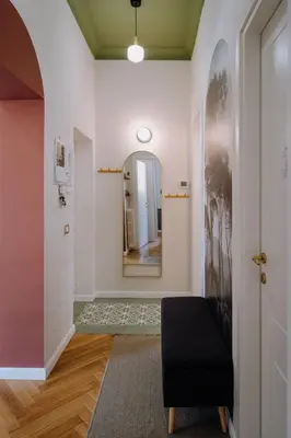 a hallway with a mirror and a black ottoman at Modern apartment in Cornelia in Rome