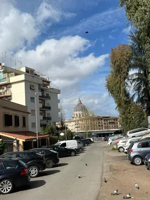 a parking lot with cars parked in front of a building at Vatican Loft a pochi passi da piazza San Pietro in Rome