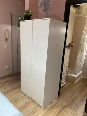 a white cabinet in a bedroom with a mirror at eternal - vatican trionfale in Rome