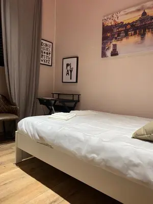 a bedroom with a white bed with a painting on the wall at eternal - vatican trionfale in Rome