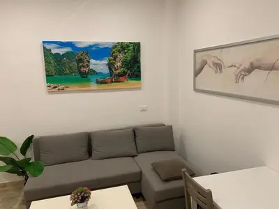 a living room with a couch and paintings on the wall at unica-vatican museum in Rome