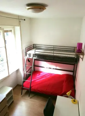 a bedroom with a bunk bed with a red blanket at Camera Privata Nomentana per medio lungo periodo in Rome