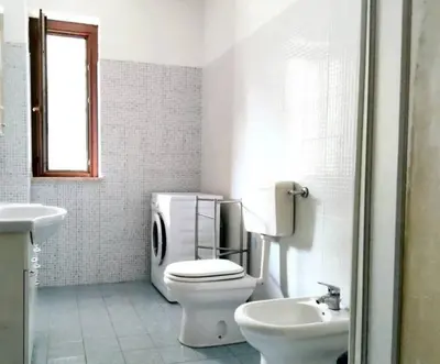 a white bathroom with a toilet and a sink at Il Colosseo Holiday home in Rome