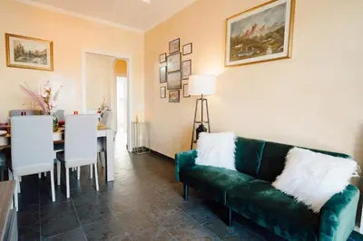 a living room with a green couch and a dining room at Dream Vacation Suites in Rome