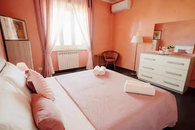 a bedroom with a bed and a dresser and a window at Dream Vacation Suites in Rome