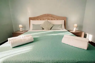 a large green bed with two pillows on it at Dream Vacation Suites in Rome