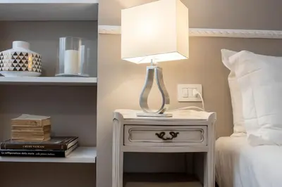 a lamp on a night stand next to a bed at Maisondesfleurs in Rome