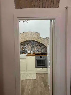 a kitchen with a door open to a kitchen with a stove at Rome City Center Apartment in Rome