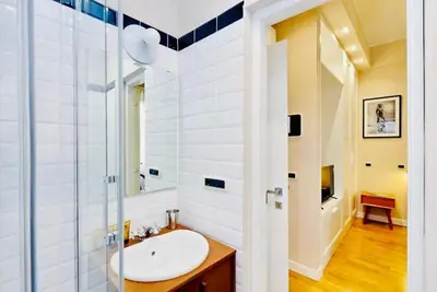 a bathroom with a sink and a glass shower at Julie's Renovated View in Rome