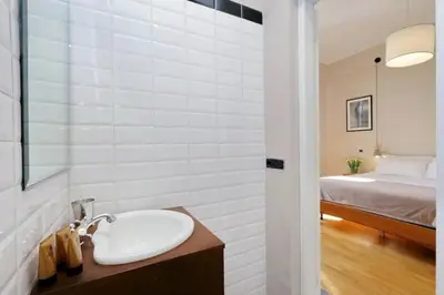 a bathroom with a sink and a bedroom with a bed at Julie's Renovated View in Rome