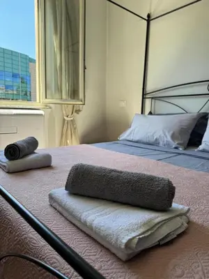 a bed with two towels on top of it at Mila House in Rome