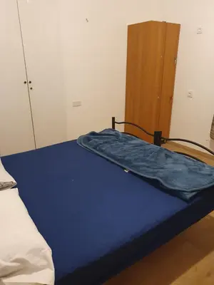 a bed with a blue sheet on it in a room at La mandragola in Rome