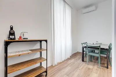 a dining room with a table and a table and chairs at BMGA l Aurelian 3Bdr 6-Guest Gem in Rome