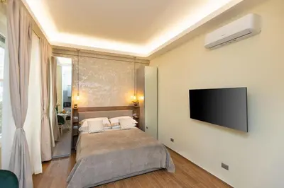 a bedroom with a bed and a flat screen tv at Dolcevita Vatican Apartment in Rome