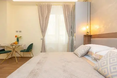 a bedroom with a bed and a table and a window at Dolcevita Vatican Apartment in Rome