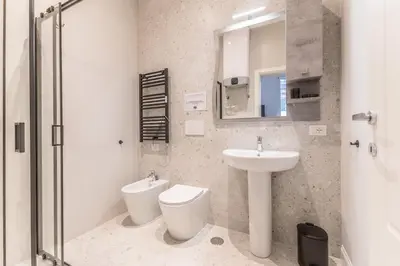 a bathroom with a sink and a toilet and a mirror at Via Nizza 126 Luxury in Rome