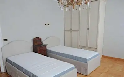 a bedroom with two beds and a chandelier at Biancaneve home in Rome