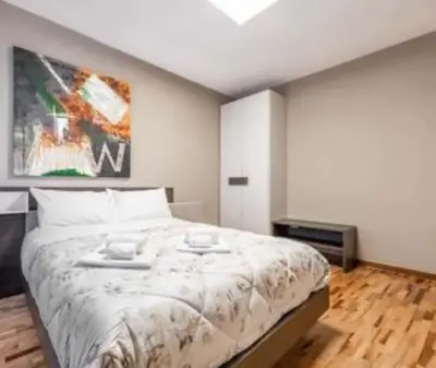 a bedroom with a large bed and a painting on the wall at Biancaneve home in Rome