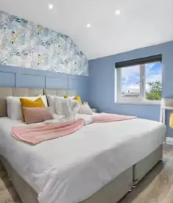 a large white bed in a blue room with a window at Biancaneve home in Rome