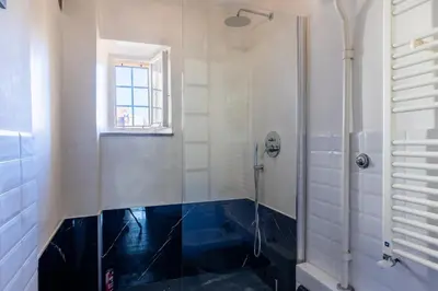 a bathroom with a shower and a blue floor at Attico Spazioso ed Elegante a Santa Maria Maggiore in Rome
