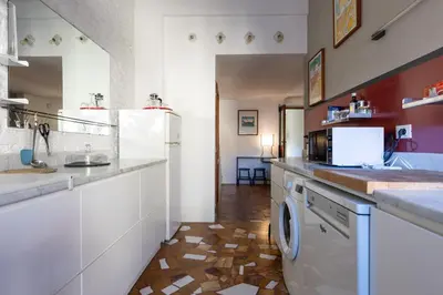 a kitchen with a white refrigerator and a dishwasher at Attico Spazioso ed Elegante a Santa Maria Maggiore in Rome