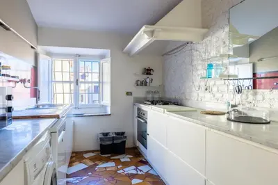 a kitchen with white cabinets and a tile floor at Attico Spazioso ed Elegante a Santa Maria Maggiore in Rome