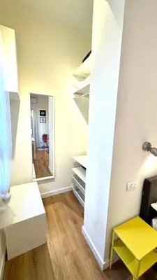 a room with white shelves and a yellow stool at Matilda House San Paolo Roma in Rome