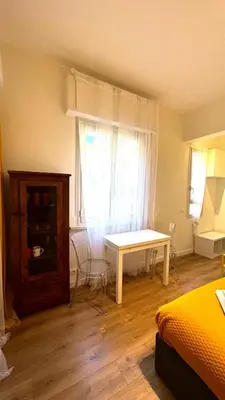 a bedroom with a bed and a table and a window at Matilda House San Paolo Roma in Rome