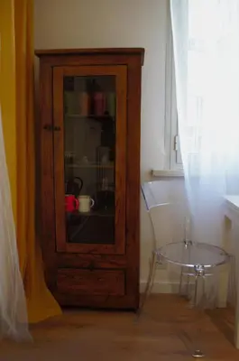a wooden cabinet with a glass table next to a window at Matilda House San Paolo Roma in Rome