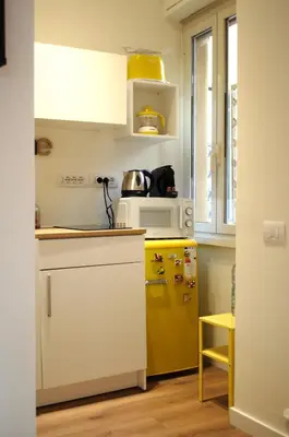 a kitchen with a yellow refrigerator and white cabinets at Matilda House San Paolo Roma in Rome