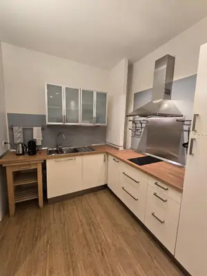 a kitchen with white cabinets and a wooden floor at Residenza Roma 19 in Rome