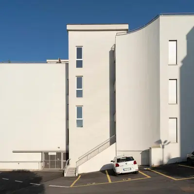 a white car parked in a parking lot in front of a building at Green park apartment in Rome