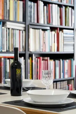 a bottle of wine next to a plate and a glass at Green park apartment in Rome