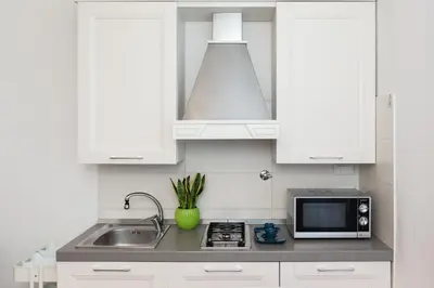 a white kitchen with a sink and a microwave at asyouRhOME - Nico - San Pietro Vaticano in Rome