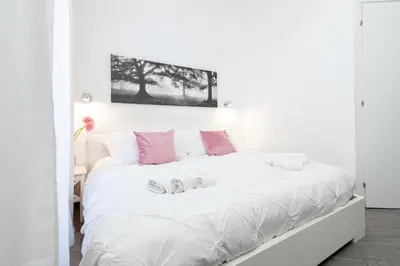 a bedroom with a white bed with two slippers on it at asyouRhOME - Nico - San Pietro Vaticano in Rome