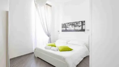 a white bedroom with a white bed with yellow pillows at asyouRhOME - Nico - San Pietro Vaticano in Rome