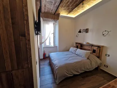 a bedroom with a bed and a large window at La casa Di Tommi a Ponte Milvio in Rome