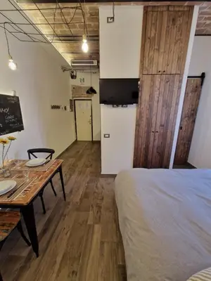 a room with a bed and a table and a kitchen at La casa Di Tommi a Ponte Milvio in Rome