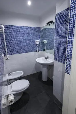 a bathroom with two toilets and a sink at Seven Kings Relais in Rome