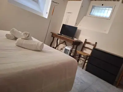 a bedroom with a bed and a desk with a television at apt treviso house in Rome