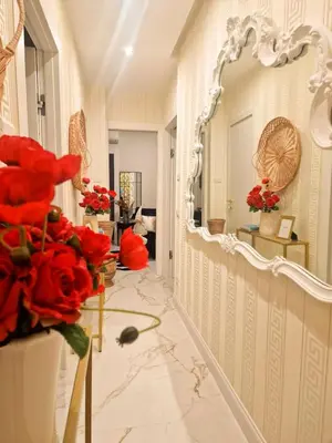 a hallway with a large mirror and red flowers at VATICANO 13 Guest House in Rome