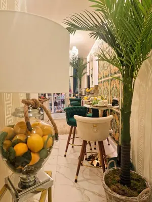 a table with a lamp and a palm tree in a room at VATICANO 13 Guest House in Rome