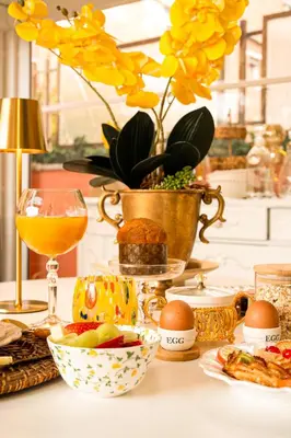 a table with food and a vase with yellow flowers at VATICANO 13 Guest House in Rome