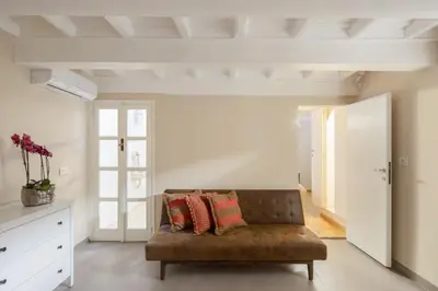 a living room with a brown couch and a window at Maison Barchetta in Via Giulia in Rome