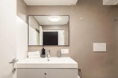 a bathroom with a white sink and a mirror at Maison Barchetta in Via Giulia in Rome