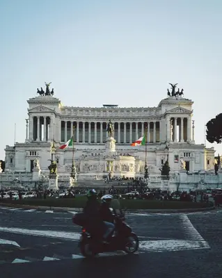 a person riding a motorcycle in front of a building at Maison Barchetta in Via Giulia in Rome
