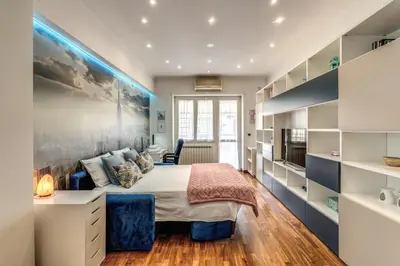 a bedroom with a bed and a large wall at New York Apartment in Rome