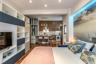 a living room with a large bed and a kitchen at New York Apartment in Rome
