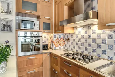 a kitchen with wooden cabinets and a stove top oven at New York Apartment in Rome