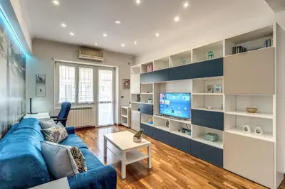 a living room with a blue couch and a tv at New York Apartment in Rome